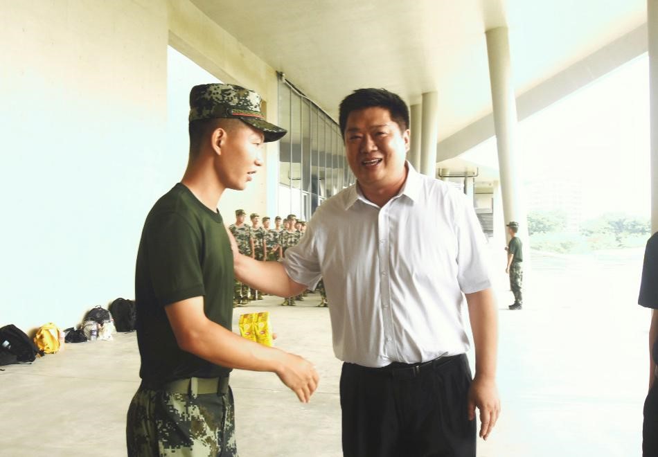 靳祥鹏递给教官饮品并感谢教官